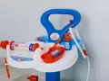 Lekfullt set med doktorsleksaker i blått och orange, inklusive en spruta med hjärtmönster och en medicinflaska.