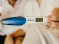 En hand håller en graviditetstest som visar "Gravid 3+". Tidiga tecken på graviditet kan vara spännande.