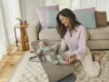 En leende mamma interagerar med sin bebis i en ergobaby babysitter.