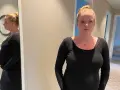Gravid kvinna med stressad blick, med sin mage synlig. Hon funderar på hur hon ska hantera gravid stress på jobb.