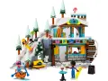 Lego Friends skidbacke med snöiga träd, en stuga och figurer som åker skidor och snowboard.
