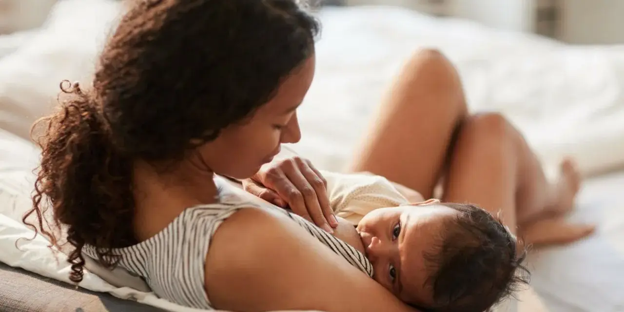 En mamma ammar sin nyfödda bebis. Den lilla bebisen, bara 2 veckor gammal, vill amma hela tiden och söker närhet hos sin mamma.