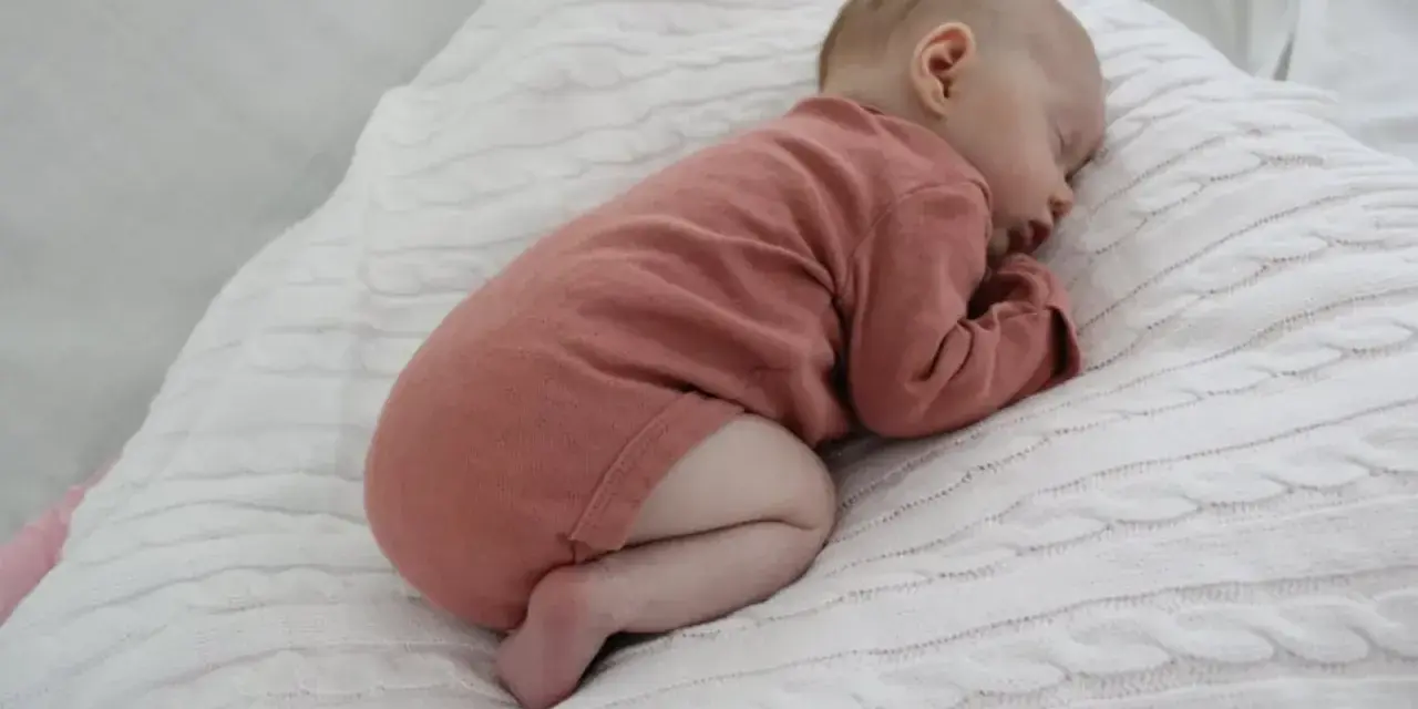 Sover sött i rosa kläder, en bebis under 1 år. Kanske drömmer om hostmedicin barn under 1 år som kan hjälpa vid förkylning.
