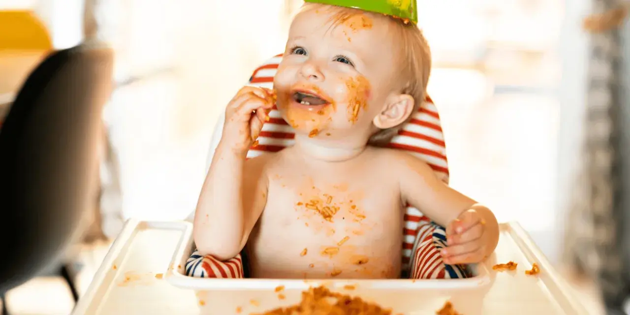 Glatt bebis med mat överallt, en festlig stund med kidsme food feeder.