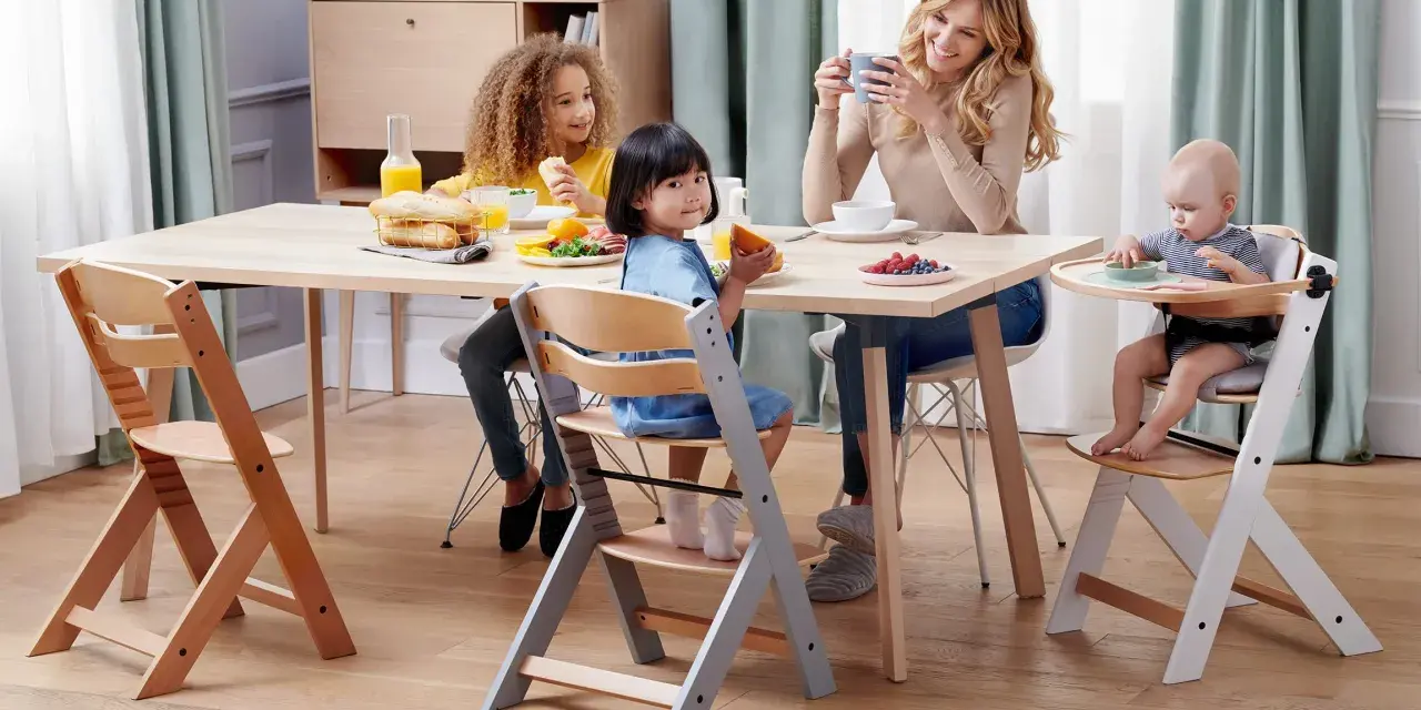 Familjen samlas kring bordet, barnen sitter i sina kinderkraft enock barnstolar och njuter av frukosten.