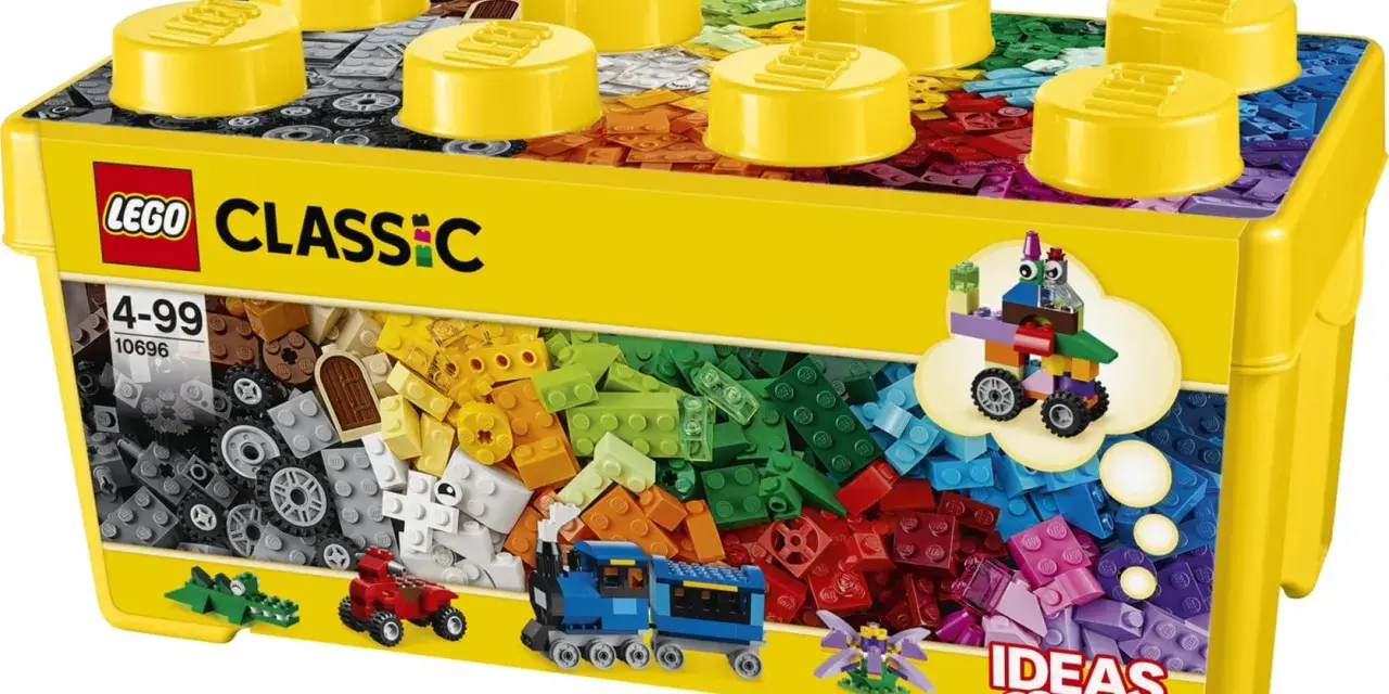 En gul låda med LEGO Classic stor samling, fylld med färgglada byggklossar. En tåg, en bil och en krokodil syns också.