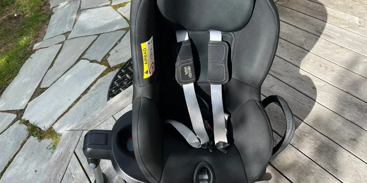 Svart Britax Römer Dualfix bilbarnstol med fempunktssele, redo för nästa äventyr.