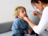 En mamma tar ett covidprov på sitt barn. Liten covid bebis får ett snabbt test.