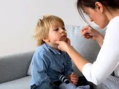 En mamma tar ett covidprov på sitt barn. Liten covid bebis får ett snabbt test.