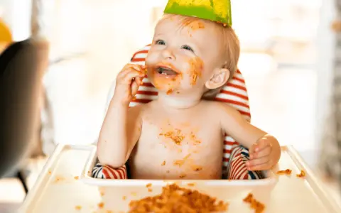 Glatt bebis med mat överallt, en festlig stund med kidsme food feeder.