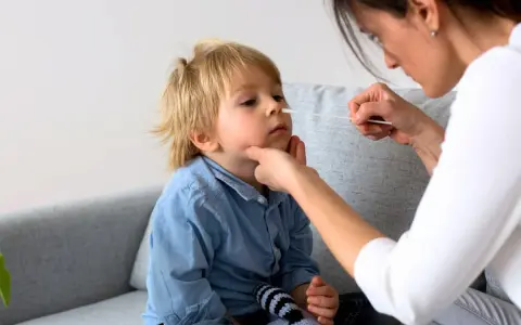 En mamma tar ett covidprov på sitt barn. Liten covid bebis får ett snabbt test.