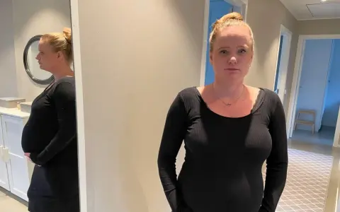 Gravid kvinna med stressad blick, med sin mage synlig. Hon funderar på hur hon ska hantera gravid stress på jobb.