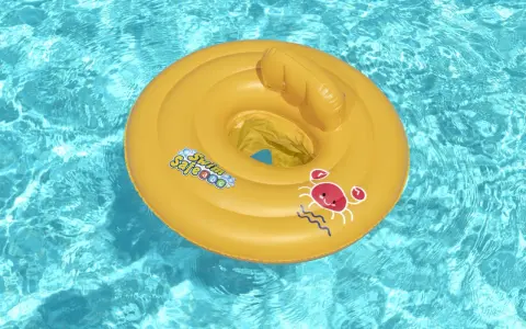 Gul badring med texten "Swim Safe" och en glad krabba flyter i klart blått poolvatten.