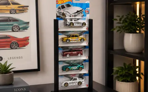 Snygg hot wheels förvaring med fem bilar i sina originalförpackningar. En vit sportbil, en gul sedan, en röd kombi, en grön sportbil och en vit racerbil.