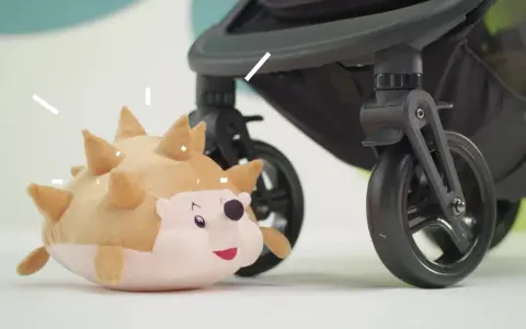 En mjuk igelkott leker bredvid ett barnvagnshjul från Kinderkraft Grande Plus.