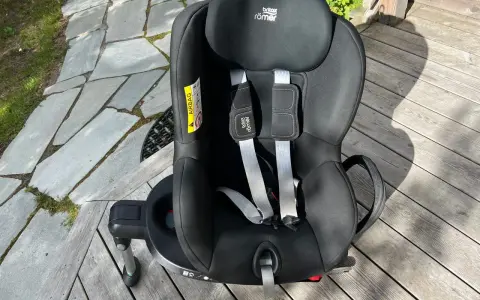 Svart Britax Römer Dualfix bilbarnstol med fempunktssele, redo för nästa äventyr.