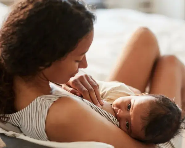 En mamma ammar sin nyfödda bebis. Den lilla bebisen, bara 2 veckor gammal, vill amma hela tiden och söker närhet hos sin mamma.