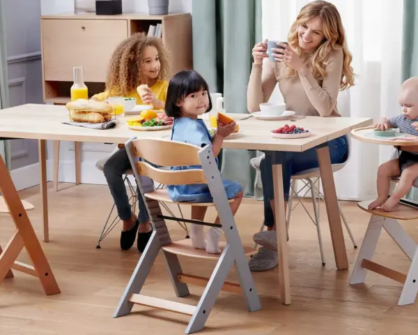 Familjen samlas kring bordet, barnen sitter i sina kinderkraft enock barnstolar och njuter av frukosten.