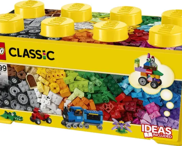 En gul låda med LEGO Classic stor samling, fylld med färgglada byggklossar. En tåg, en bil och en krokodil syns också.