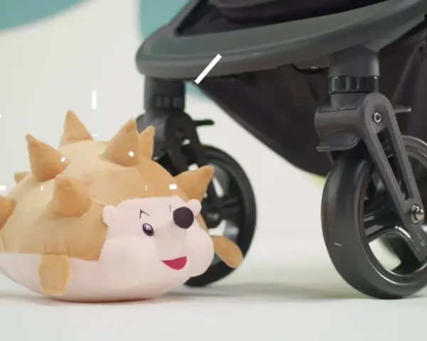 En mjuk igelkott leker bredvid ett barnvagnshjul från Kinderkraft Grande Plus.