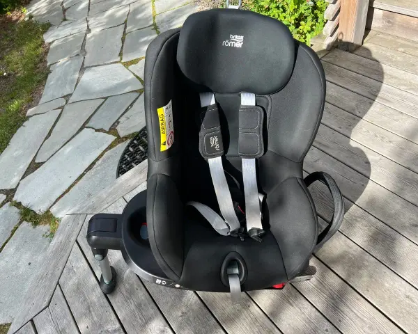 Svart Britax Römer Dualfix bilbarnstol med fempunktssele, redo för nästa äventyr.