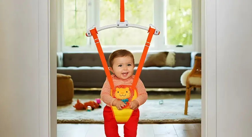 Glad baby i en hoppgunga ställning, redo för skoj och studs i vardagsrummet.