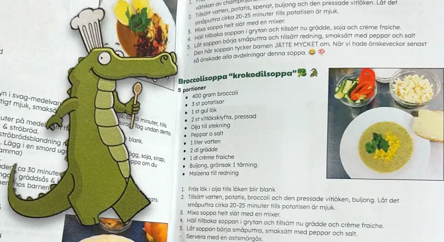 En glad krokodilkock med en sked i handen presenterar receptet på "Krokodilsoppa". En perfekt rese potta för små äventyrare!