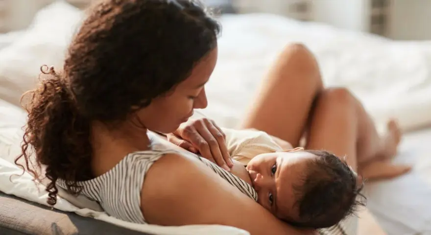 En mamma ammar sin nyfödda bebis. Den lilla bebisen, bara 2 veckor gammal, vill amma hela tiden och söker närhet hos sin mamma.