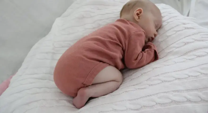 Sover sött i rosa kläder, en bebis under 1 år. Kanske drömmer om hostmedicin barn under 1 år som kan hjälpa vid förkylning.