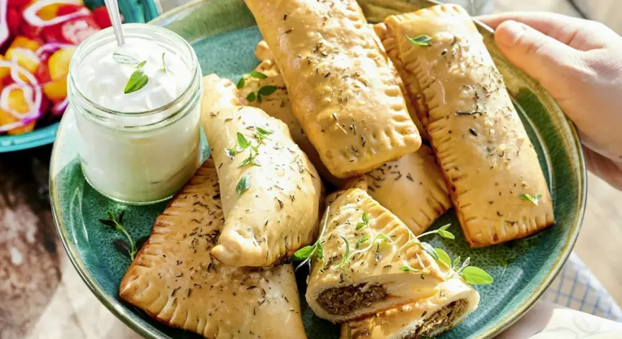 En tallrik med gyllene piroger, perfekta som mellis för en 1-åring. Serveras med en klick krämig dipp och färska örter.