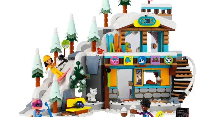 Lego Friends skidbacke med snöiga träd, en stuga och figurer som åker skidor och snowboard.