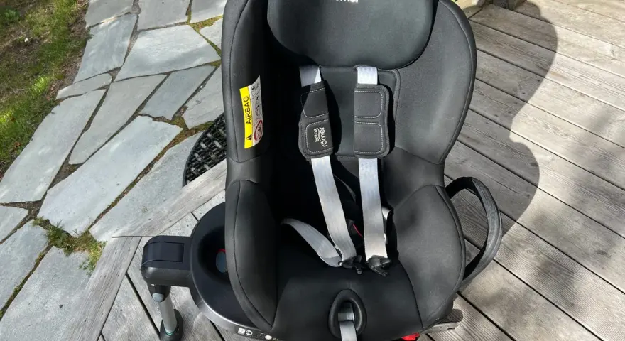 Svart Britax Römer Dualfix bilbarnstol med fempunktssele, redo för nästa äventyr.