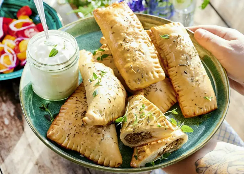 En tallrik med gyllene piroger, perfekta som mellis för en 1-åring. Serveras med en klick krämig dipp och färska örter.